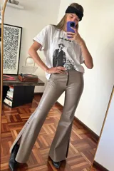 Pantalón Oxford de cuero ovino color visón con pasamanería a tono en los tajos laterales. Cierre frontal con cremallera.