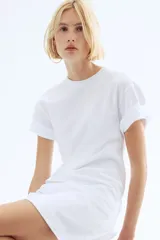 Vestido corto en punto de algodón suave con cuello redondo ribeteado acanalado, hombros caídos y mangas al codo. Pinzas moldeadoras en la parte posterior de la cintura para estilizar la figura.