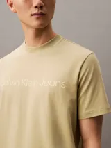 Remera color arena de corte regular, cuello redondo y manga corta. Estampado frontal con el logo de Calvin Klein Jeans en color blanco.