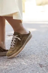 Mocasín de cuero color verde oliva, con cordones y suela marrón.