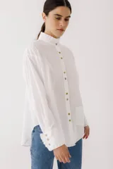 Camisa blanca de algodón con pespuntes cobrizos y detalle de volado en mangas y cuello.