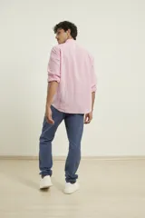 Camisa azul marino de lino y algodón, con cuello abotonado, manga larga con puños enrollados, bolsillo de parche en el pecho y cierre frontal con botones.