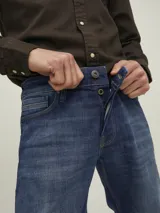 Jean azul de tiro medio y corte tapered, con diseño clásico de cinco bolsillos y cierre con botón.