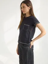 Remera negra de algodón con bolsillo frontal y bordado.