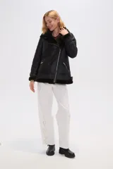 Campera negra de eco cuero con cuello de piel sintética, cierre cruzado con cremallera y bolsillos laterales con cremallera.