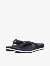 Ojotas azul marino con plataforma blanca y tira de crochet con logo dorado de la marca.