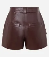 Short pollera corto color bordó, confeccionado en poliuretano (PU), con bolsillos delanteros grandes con solapas y cierre por cremallera.