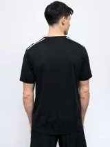 Remera deportiva Umbro negra de manga corta, con cuello redondo y tres franjas blancas en los hombros.