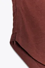 Top palabra de honor negro con escote recto, pliegues y bajo asimétrico.