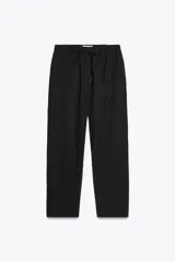 Pantalón tobillero negro con cintura elástica ajustable con cordones, bolsillos delanteros y falsos bolsillos con solapa en la espalda.