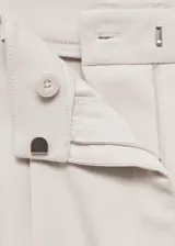 Pantalón de vestir color beige, de corte recto y tiro medio, con pinzas delanteras, bolsillos laterales y traseros.