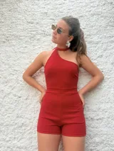 Mono corto de crepe color rojo, con escote asimétrico, un solo tirante y calce ajustado.