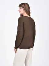 Buzo de tejido de punto negro, con cuello en V y mangas largas. Presenta franjas horizontales con pequeños calados decorativos.