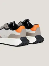 Zapatillas Tommy Jeans de estilo running, color gris con detalles en naranja y negro. Confeccionadas en piel y materiales reciclados.