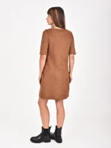 Vestido corto negro de gamuza sintética, con cuello redondo, mangas cortas y dos bolsillos frontales.