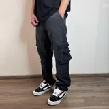 Pantalón jean cargo gris oscuro, corte holgado, con bolsillos laterales y traseros.