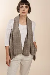 Chaleco marrón con diseño a cuadros, solapas anchas y bolsillos laterales.