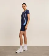 Remera deportiva blanca de microfibra texturizada, con cuello redondo, mangas cortas y estampa lateral de ondas en azul y fucsia.