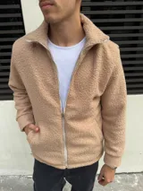 Campera de algodón color beige con textura de corderito, cierre frontal y cuello alto.
