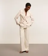 Blazer oversized color beige confeccionado en tweed. Posee cuello inglés, mangas largas, detalles de botones aplicados y solapas que imitan bolsillos.