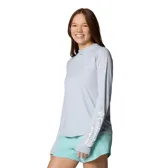 Remera con capucha Columbia Tidal Tee II para mujer, color gris claro. Confeccionada en tejido transpirable con protección solar UPF 40 y tecnología Omni-Wick de secado rápido.
