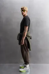 Pantalón de jogging color marrón oscuro, corte regular fit, confeccionado en tejido técnico ligero y elástico. Cuenta con cintura elástica ajustable con cordón, bolsillos frontales con cierre de cremallera, bolsillo trasero con cierre de cremallera oculta en costura y bajo ajustable con elástico.