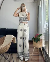 Conjunto de top sin mangas y pantalón palazzo con cintura elastizada, ambos de color crudo con estampado de flores y motivos geométricos en negro.