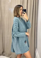 Sweater tejido de punto color fucsia con diseño de trenzas verticales en color naranja. Tiene cuello redondo y dos bolsillos frontales.