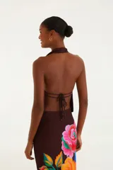 Top corto marrón con escote halter en V pronunciado y frunce bajo el busto. Presenta ajuste en la espalda y detalle de rosas que aporta un acento distintivo.