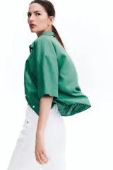 Camisa verde de lino y viscosa, de corte holgado, con cuello clásico, cierre frontal con botones y mangas 3/4.