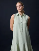 Vestido corto blanco de gasa, sin mangas, con cuello camisero, abertura central con botones y terminación de ruedo con volado.