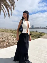 Falda larga negra de corte amplio con volados en el ruedo.