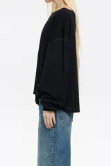 Camiseta negra de manga larga con corte holgado, cuello redondo y pespuntes a contratono.