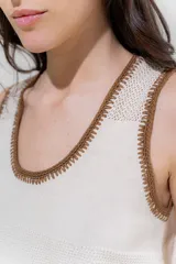 Musculosa de punto color salmón con cuello y sisas ribeteadas en rojo.