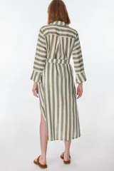 Vestido camisero largo a rayas horizontales verdes y blancas, con cuello clásico, mangas 3/4 y abertura frontal con botones. Confeccionado en lino.