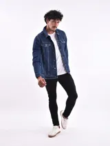 Campera de jean azul con cuello clásico, cierre frontal con botones metálicos, bolsillos con solapa abotonada en el pecho y bolsillos laterales.
