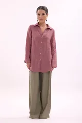 Camisa de manga larga, color rosa viejo, con cuello camisero y botones frontales. Presenta un calce holgado.