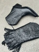 Bucaneras negras de cuero con caña alta y flecos desmontables.