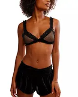 Bralette negro de malla transparente con lunares y detalles de encaje con volados en el contorno y los tirantes.