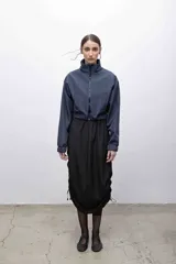 Campera cropped azul con cuello alto y cierre frontal. Cuenta con bolsillos funcionales, puños elastizados e interior de micropolar.