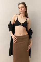 Top de bikini negro con textura sutil y aro rectangular dorado en el centro. Breteles finos y espalda con cierre de gancho.
