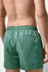Short de baño verde con elástico y cordón ajustable en la cintura, bolsillos laterales y trasero con cierre autoadherente.