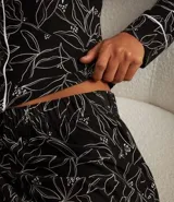 Conjunto de pijama americano confeccionado en peach touch, estampado de follajes con detalles de vieses contrastantes. Incluye camisa de manga larga con cuello solapa y abotonado delantero, y pantalón con cintura elástica.