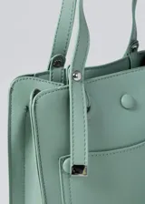 Cartera de cuero sintético en color rosa, con un compartimento y bolsillos con cierre.