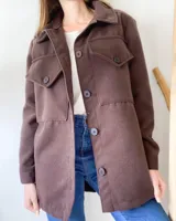 Camisa leñadora marrón con cuello clásico, cierre frontal con botones y bolsillos con solapa en el pecho.
