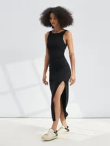 Vestido midi negro de punto, sin mangas, con cuello redondo y abertura lateral en la falda.