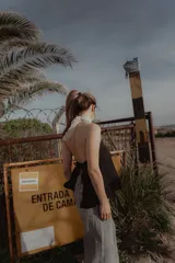 Top negro con cuello halter de puntilla blanca, sin mangas y espalda descubierta.