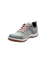Zapatillas urbanas Hush Puppies modelo Rising Low, color gris con detalles en gris oscuro y rosa. Capellada textil impermeable, cordones rosas y suela de goma marrón.
