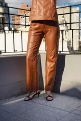 Pantalón de cuero color marrón con costuras verticales en el frente.