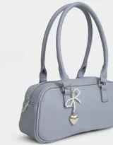 Bandolera tipo baguette color celeste con doble asa corta de mano y charm decorativo de moño de perlas y corazón de metal.
